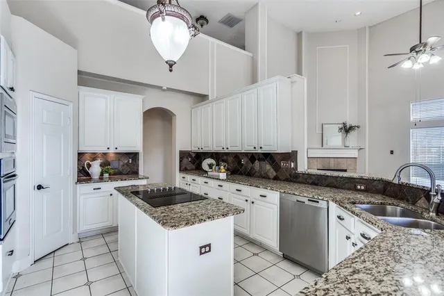 a kitchen with a sink a counter top space cabinets and stainless steel appliances