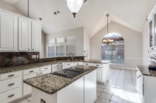 a kitchen with granite countertop a sink stove and cabinets