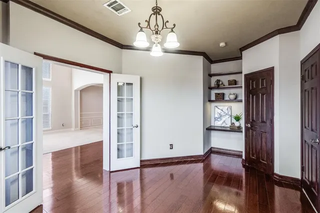 a view of a hallway with wooden floor and livingroom with furniture