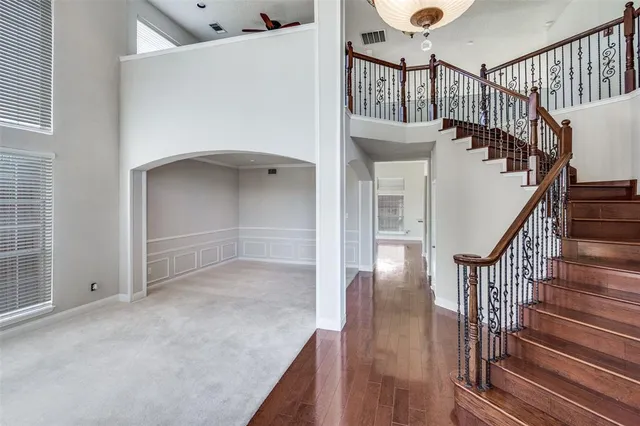 a view of staircase with lots of frames on wall and wooden floor