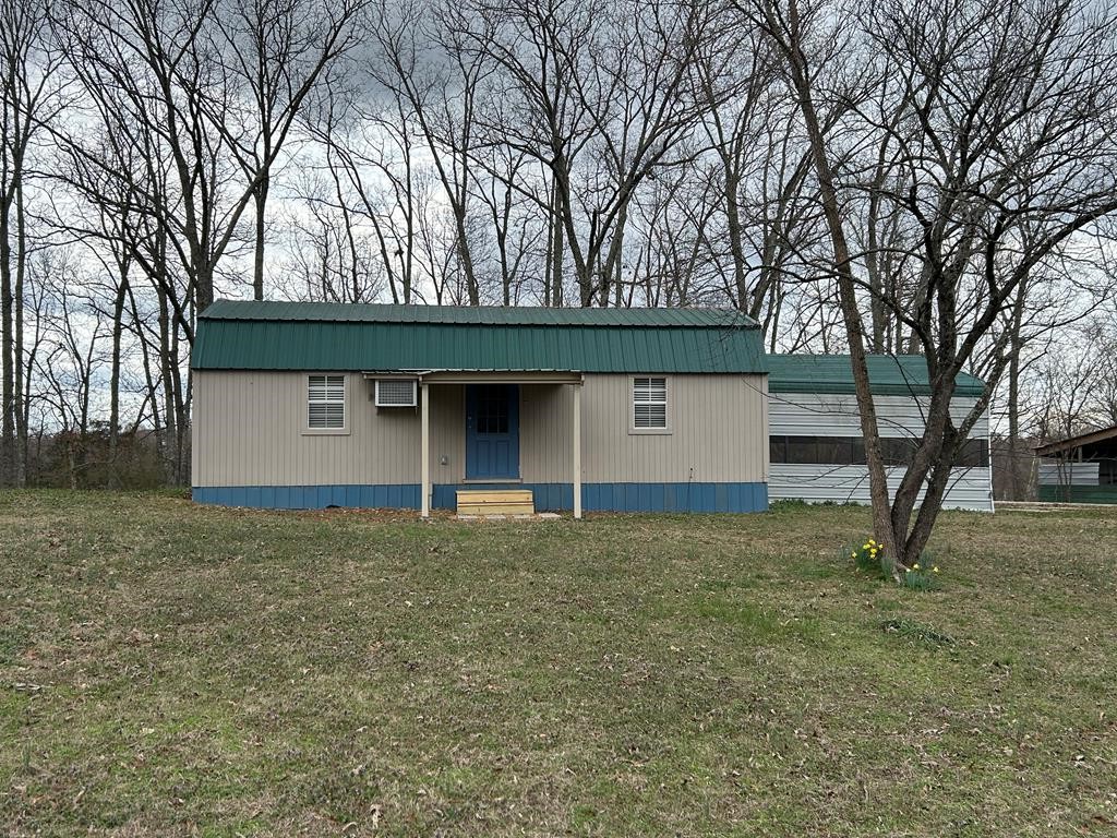 130 Clement Street Big Sandy, TN 38221 - Photo 1 of 17 a house with trees in front of it