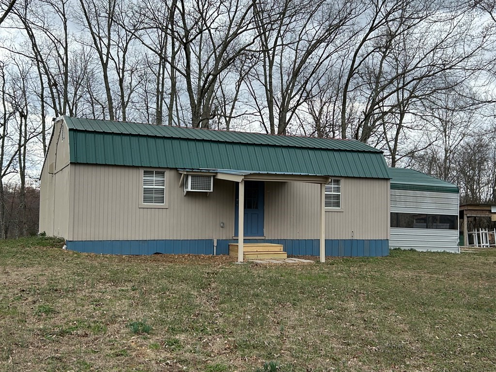 130 Clement Street Big Sandy, TN 38221 - Photo 2 of 17 a house with trees in the background