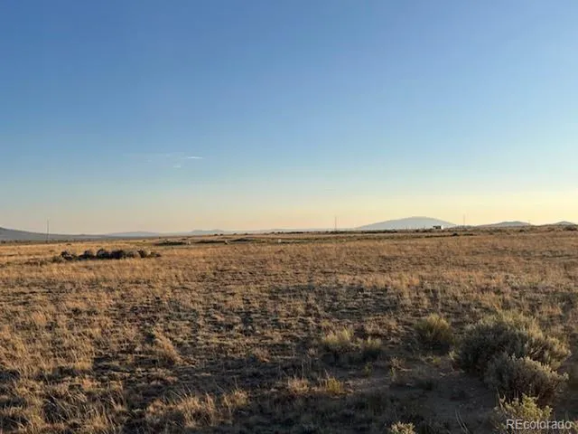 an aerial view of house with yard and mountain view in back