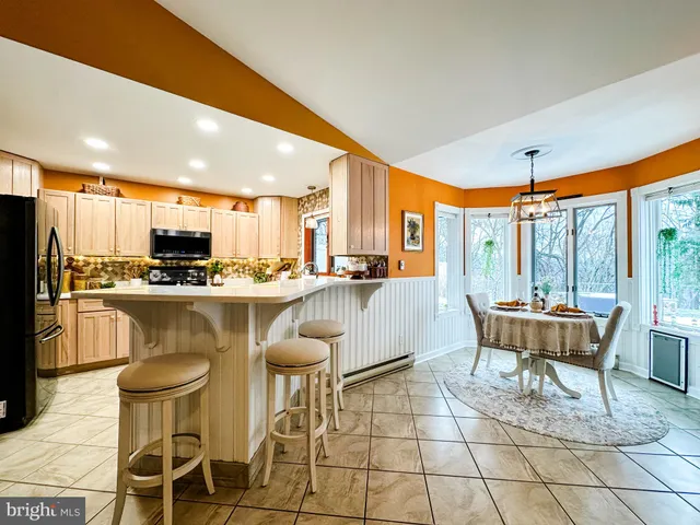 a dining table chairs and a glass door with the kitchen view