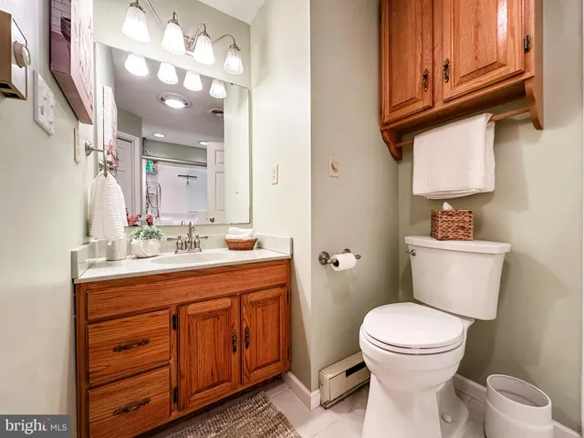 a bathroom with a granite countertop toilet sink and mirror