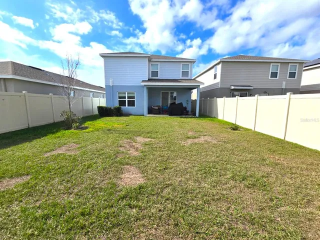 a view of a house with backyard and garden