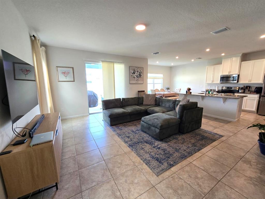 10682 Old Sycamore Loop Land O Lakes, FL 34638 - Photo 9 of 22 a living room with furniture a large window and a flat screen tv