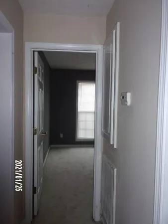 a view of a hallway with wooden shelves