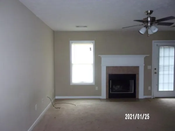 a view of an empty room with a fireplace and a window