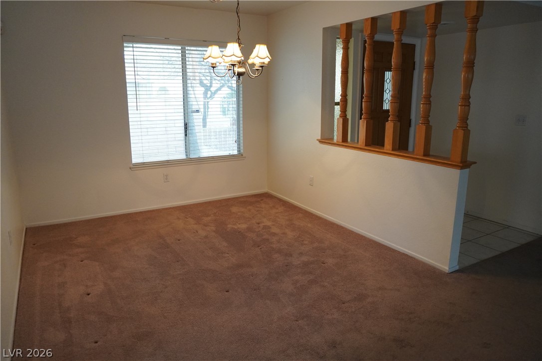8328 Del Rey Avenue Las Vegas, NV 89117 - Photo 22 of 38 A classic chandelier illuminates this spacious, well-lit dining area featuring a privacy-enhancing window.