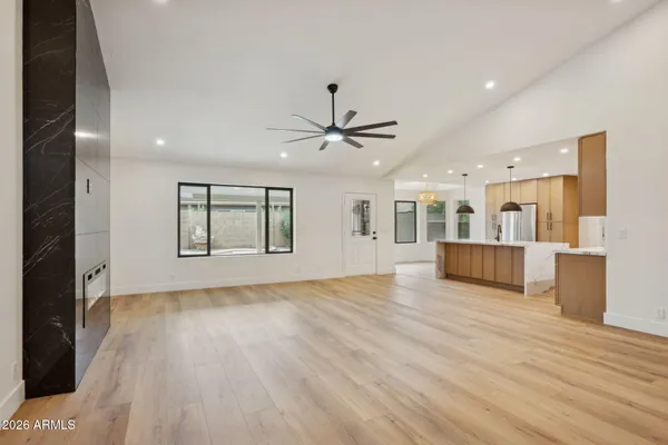 a view of an empty room with window and wooden floor