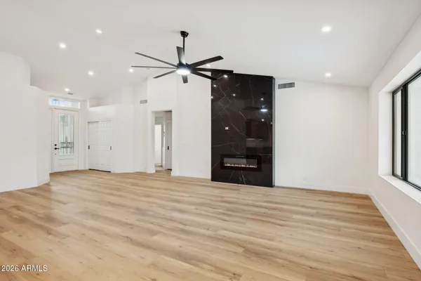 a view of an empty room with a window and wooden floor