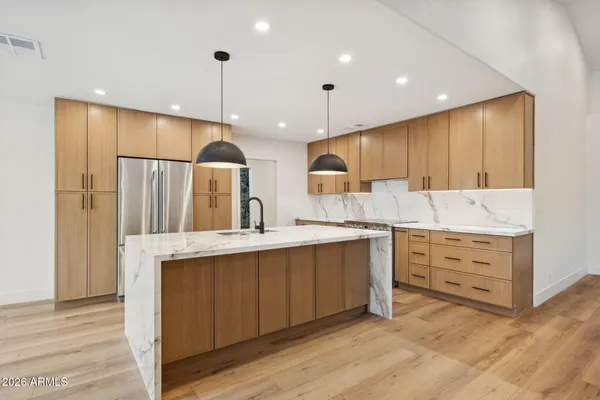 a large kitchen with kitchen island a sink stainless steel appliances and cabinets