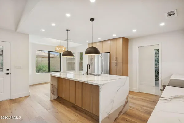 a kitchen with granite countertop cabinets stainless steel appliances and wooden floor