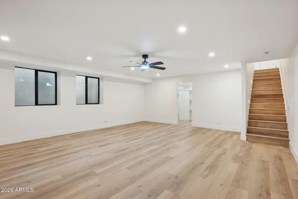 a view of a big room with wooden floor and windows