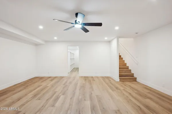 an empty room with a ceiling fan and wooden floor
