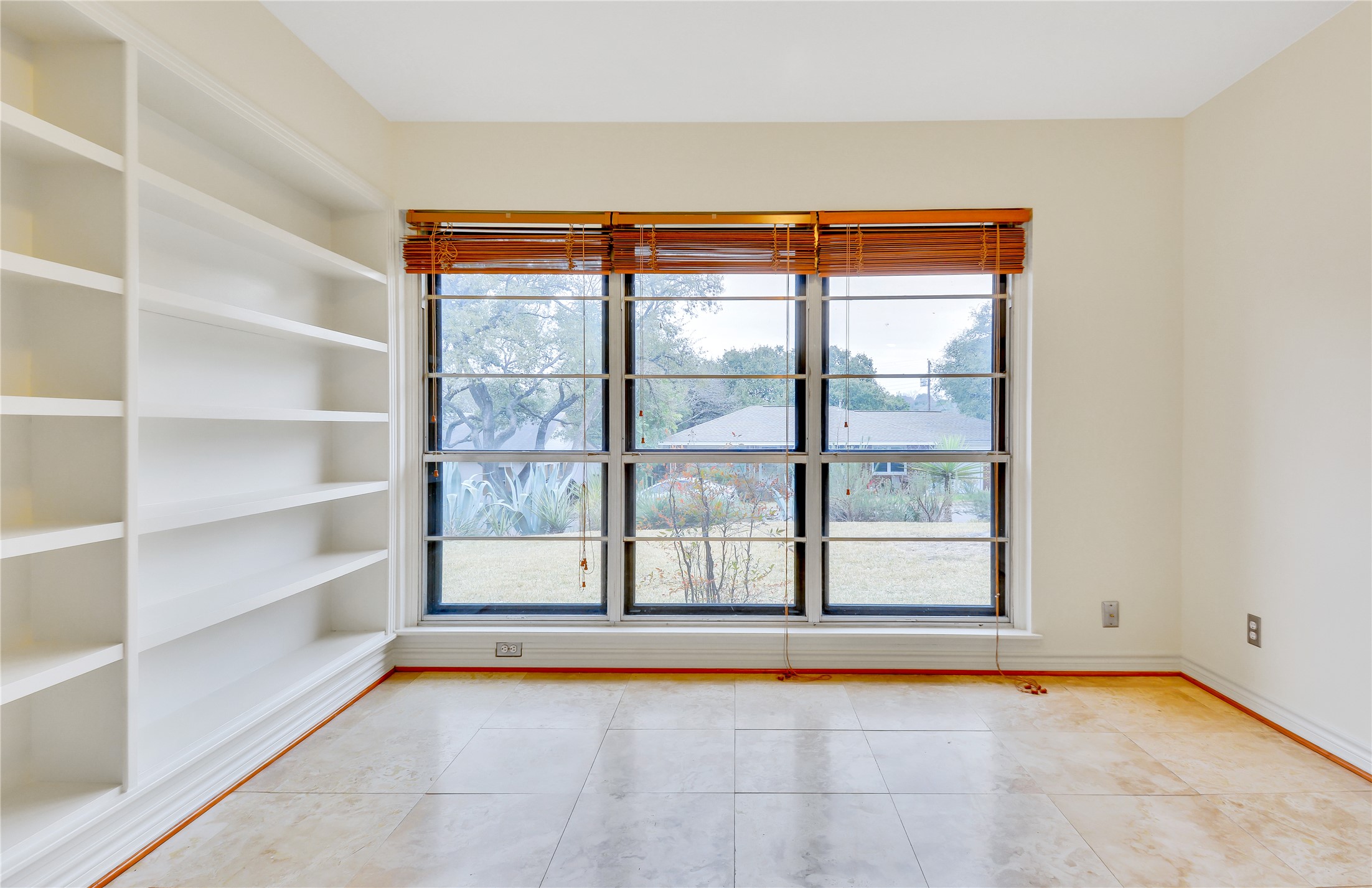 2300 Rebel Road Austin, TX 78704 - Photo 7 of 26 Floor-to-ceiling built-in shelving complements the light-filled interior, offering abundant storage or display options.