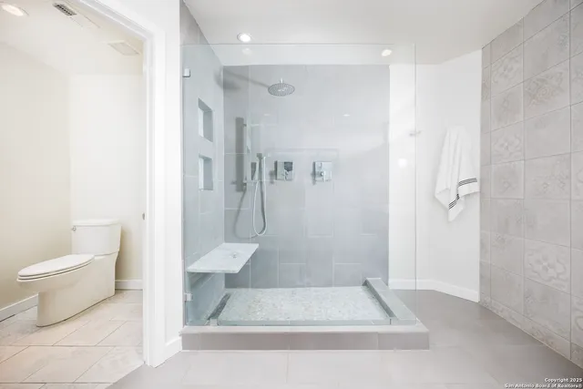 a bathroom with a toilet and a shower