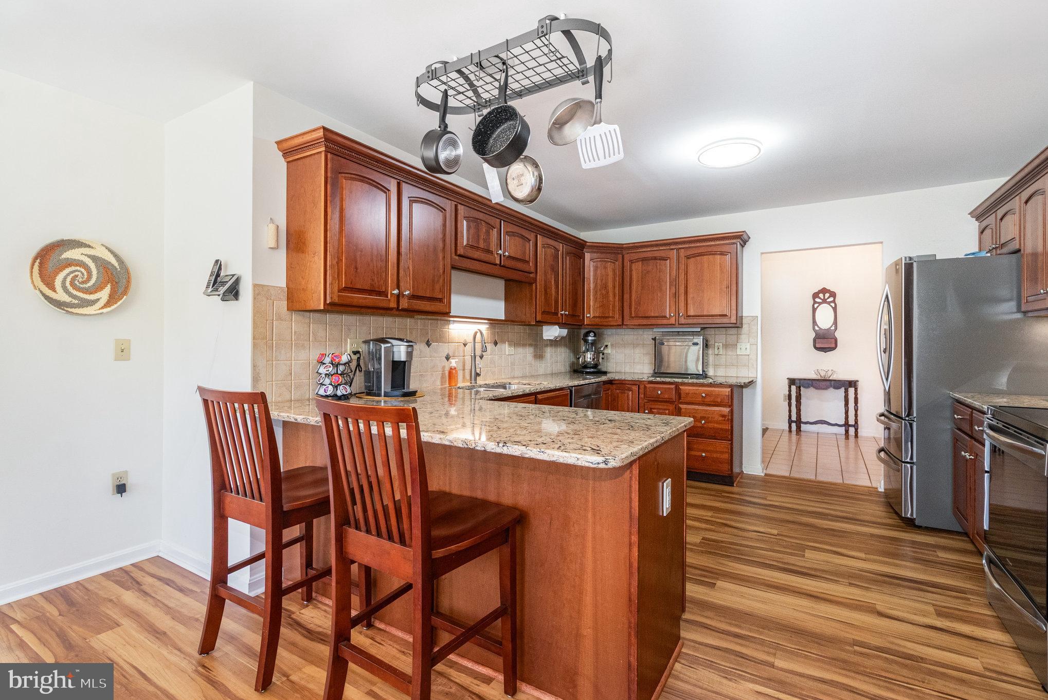 258 Bonnybrook Road Carlisle, PA 17015 - Photo 8 of 31 a kitchen with stainless steel appliances granite countertop a sink a stove a refrigerator cabinets and chairs