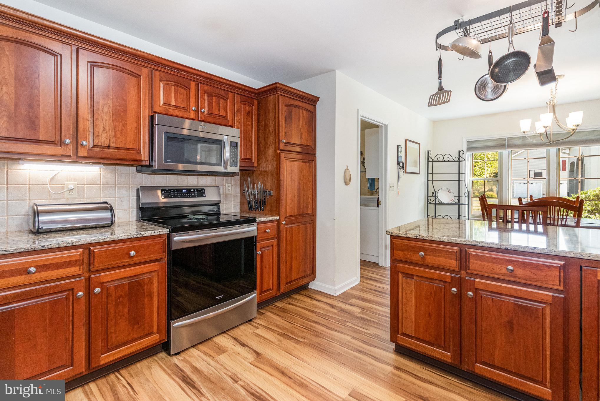 258 Bonnybrook Road Carlisle, PA 17015 - Photo 10 of 31 a kitchen with stainless steel appliances granite countertop wooden cabinets a stove a sink and dishwasher with wooden floor