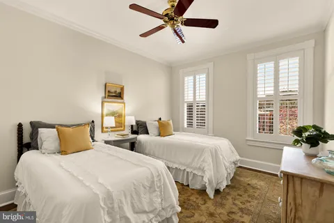 a bedroom with two beds and potted plant