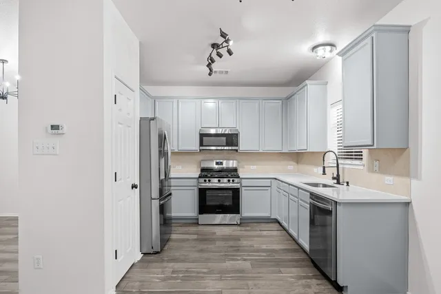 a kitchen with stainless steel appliances a sink stove and refrigerator