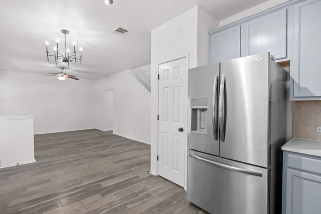 a kitchen with stainless steel appliances a refrigerator and wooden floor