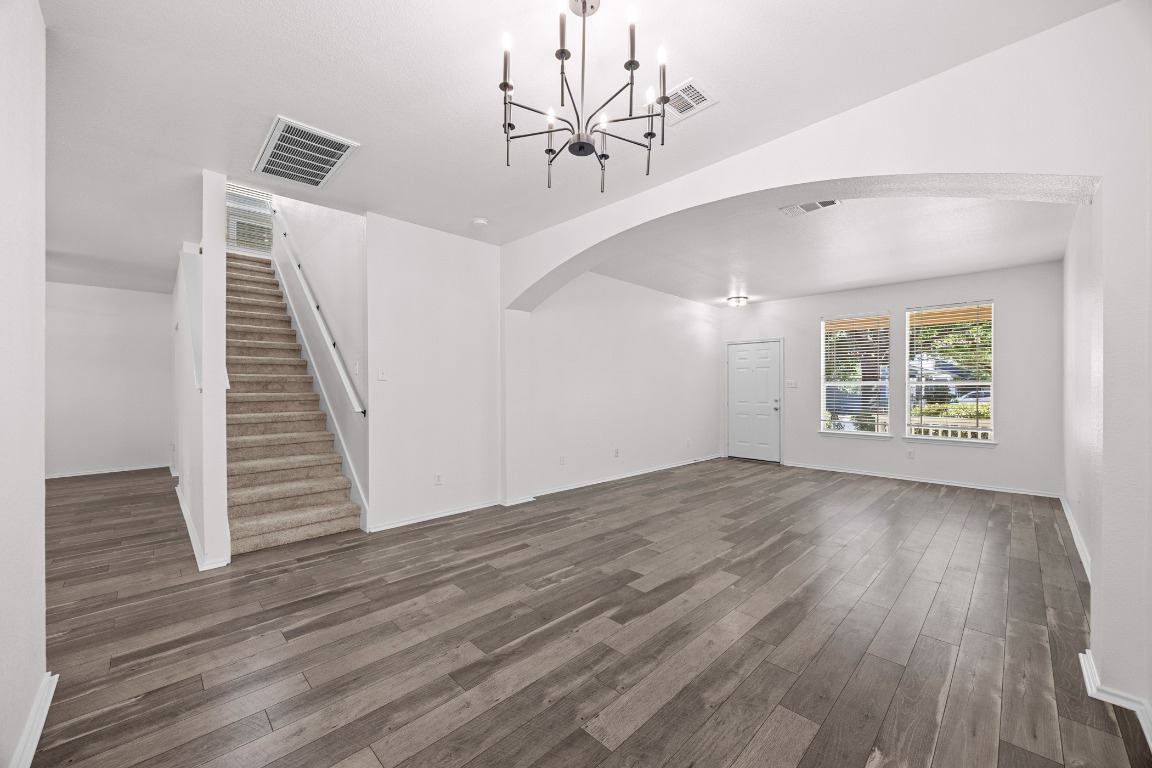 10208 Laredo Drive, Unit 105 Austin, TX 78748 - Photo 10 of 37 an empty room with wooden floor chandelier fan and windows