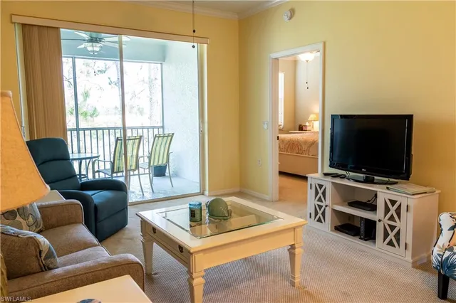 a living room with furniture kitchen view and a large window