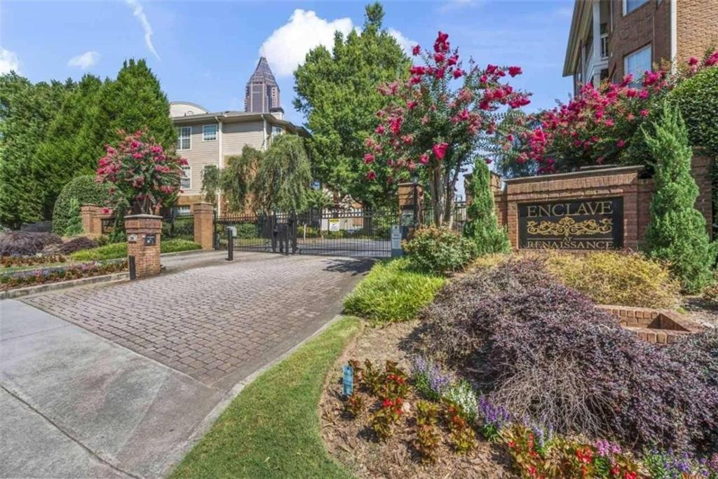 a sign board with flower plants and wooden fence