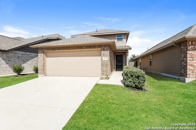 a front view of a house with a yard and garage