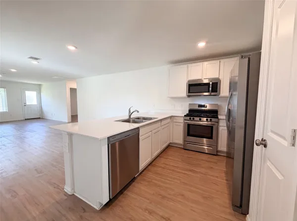 a kitchen with stainless steel appliances a sink and a refrigerator