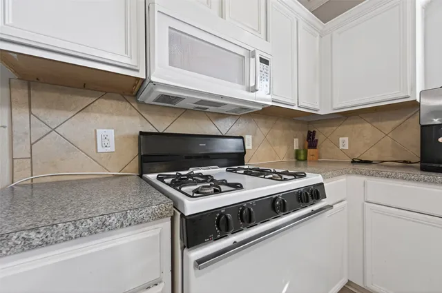 a stove top oven sitting inside of a kitchen