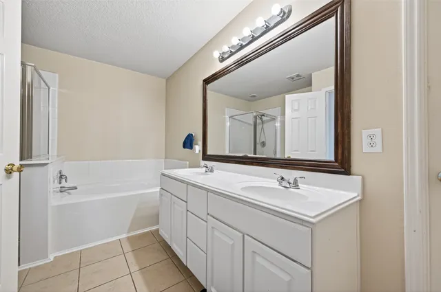 a bathroom with a sink a large mirror and a bathtub