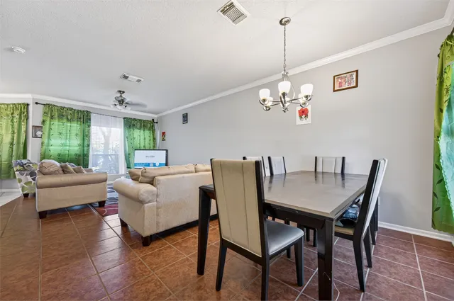 a dining room with furniture a chandelier and wooden floor