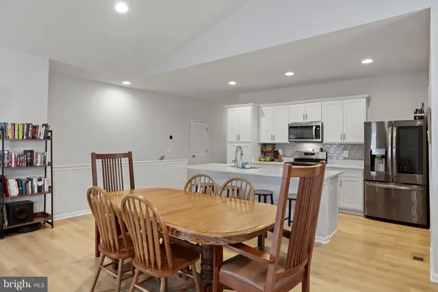 a view of kitchen with refrigerator a microwave and wooden floor