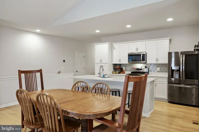 a view of kitchen with granite countertop window dining table and stainless steel appliances