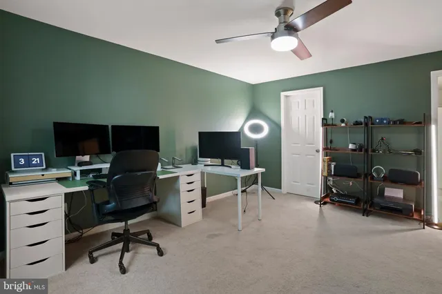 a view of a workspace with furniture and a window