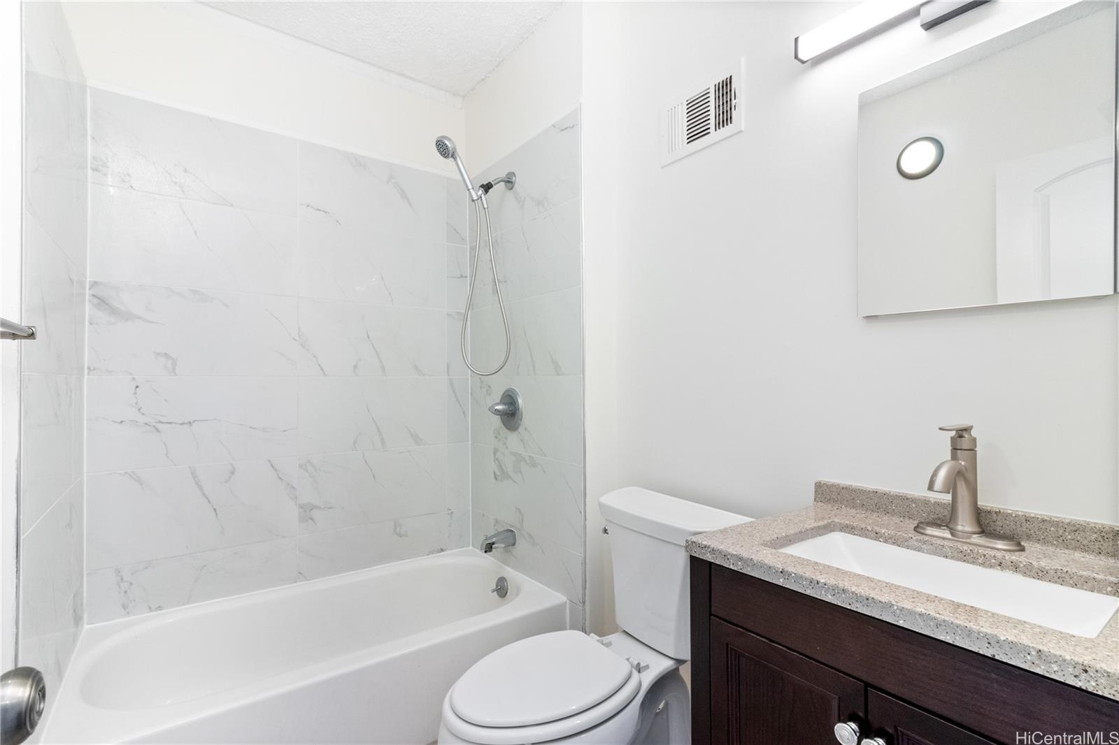 94-249 Waikele Road, Unit A307 Waipahu, HI 96797 - Photo 11 of 20 a bathroom with a granite countertop sink toilet and shower