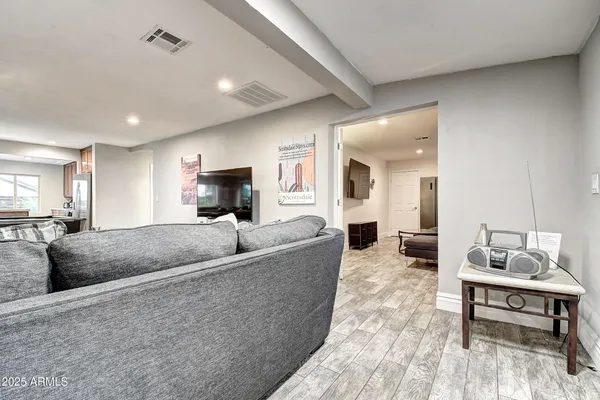 a kitchen with stainless steel appliances kitchen island granite countertop a stove a refrigerator a sink a dining table and chairs with wooden floor
