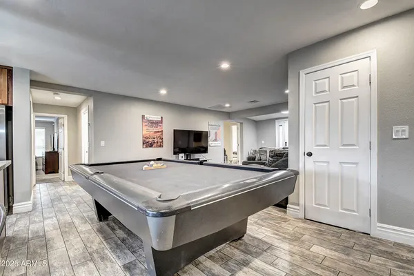 a kitchen with a stove a sink a kitchen island with chairs and wooden floor