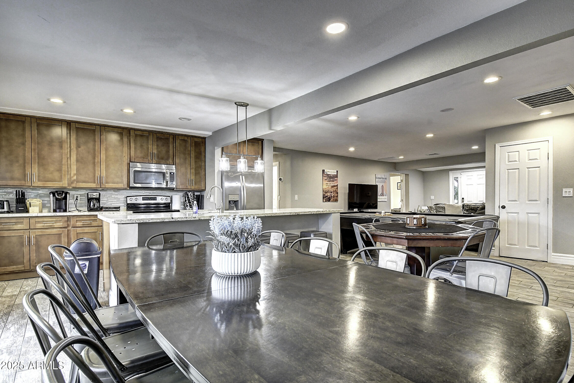 4101 East Nisbet Road Phoenix, AZ 85032 - Photo 28 of 64 a kitchen with a dining table chairs stainless steel appliances and cabinets