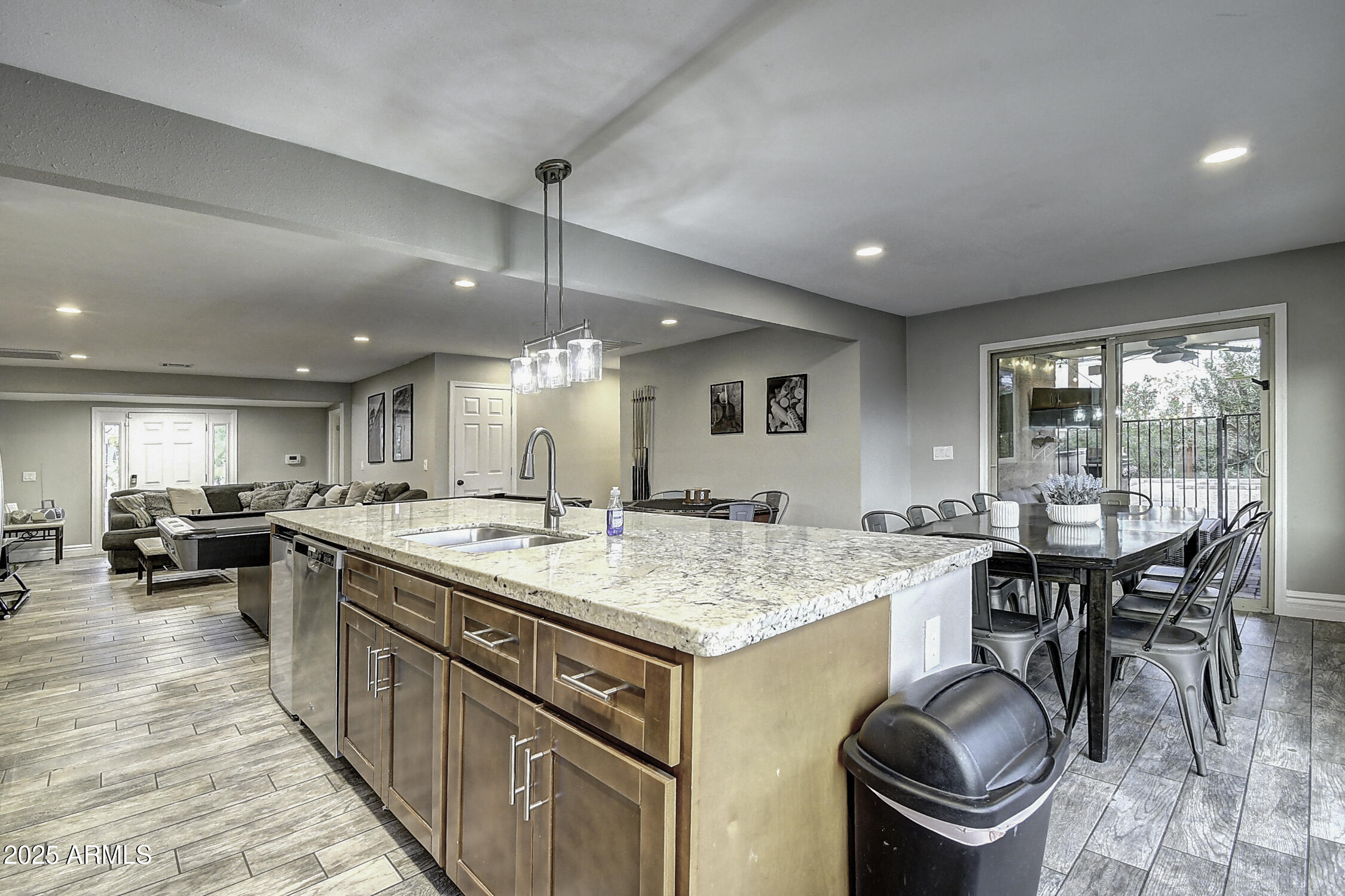 4101 East Nisbet Road Phoenix, AZ 85032 - Photo 34 of 64 a kitchen with a stove a sink a kitchen island with chairs and wooden floor