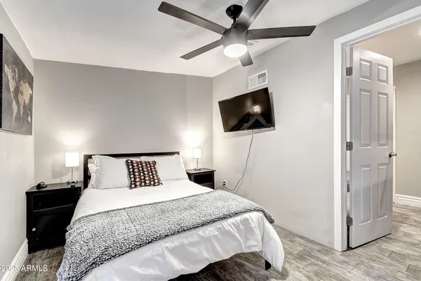 a bedroom with a bed and a desk with stool