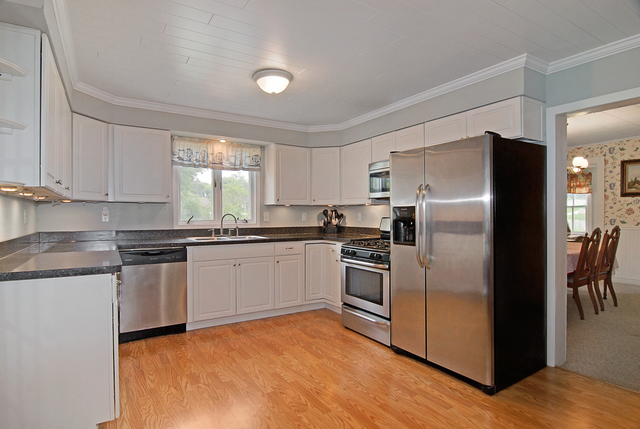 128 Howard Street Geneva, IL 60134 - Photo 4 of 29 a kitchen with granite countertop a refrigerator and a stove top oven