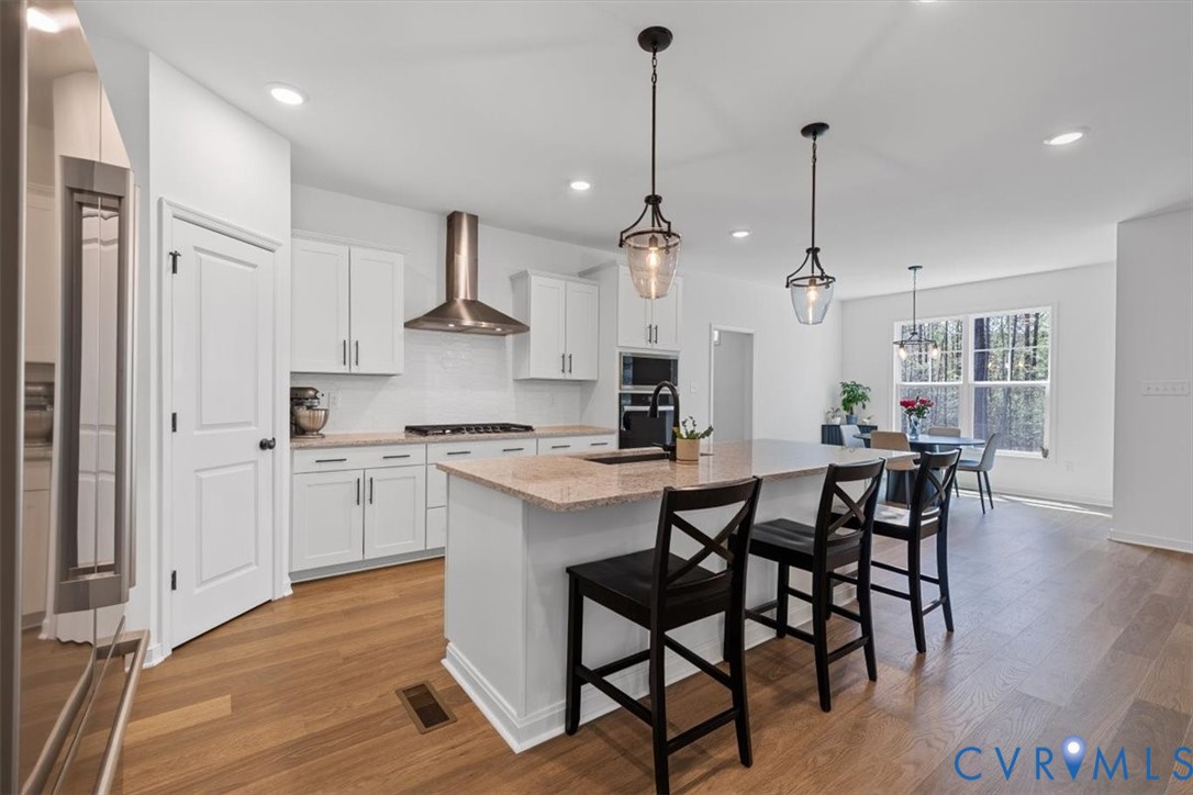 17131 Westington Road Moseley, VA 23120 - Photo 11 of 34 a kitchen with stainless steel appliances kitchen island granite countertop a wooden floor and white cabinets