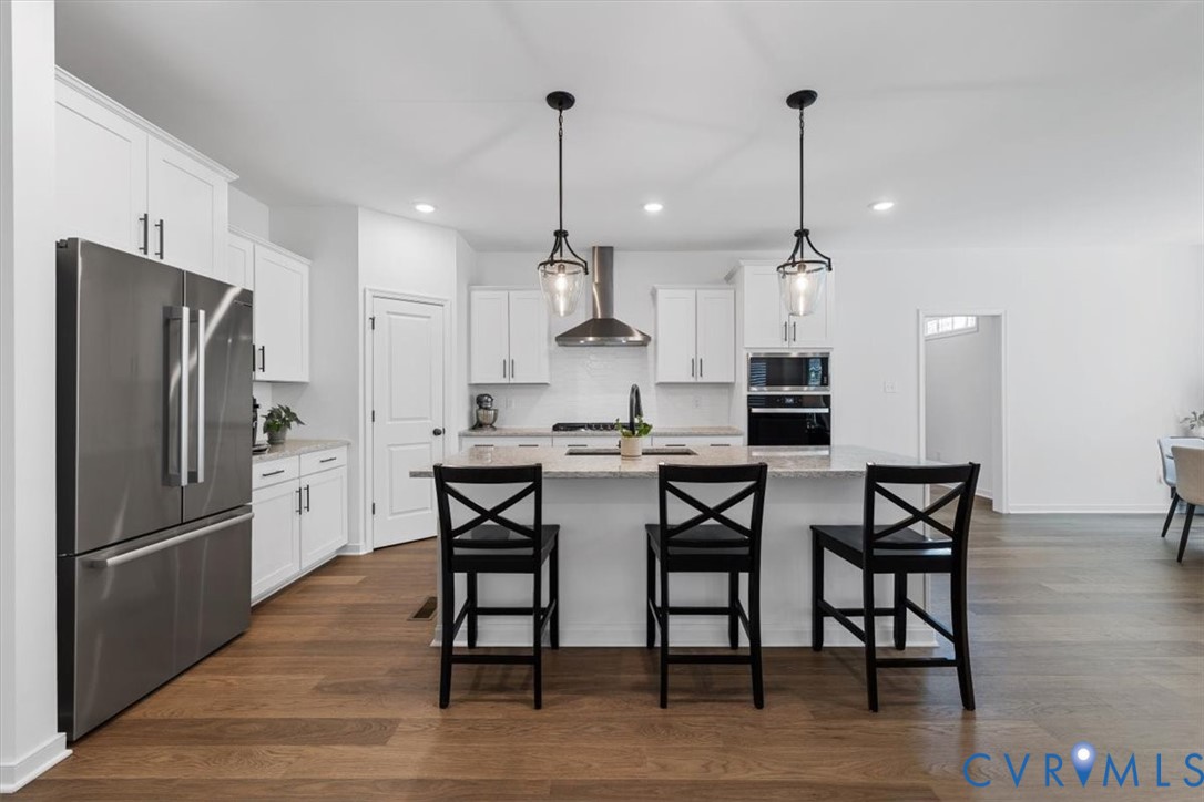 17131 Westington Road Moseley, VA 23120 - Photo 12 of 34 a kitchen with stainless steel appliances granite countertop a dining table chairs refrigerator and microwave
