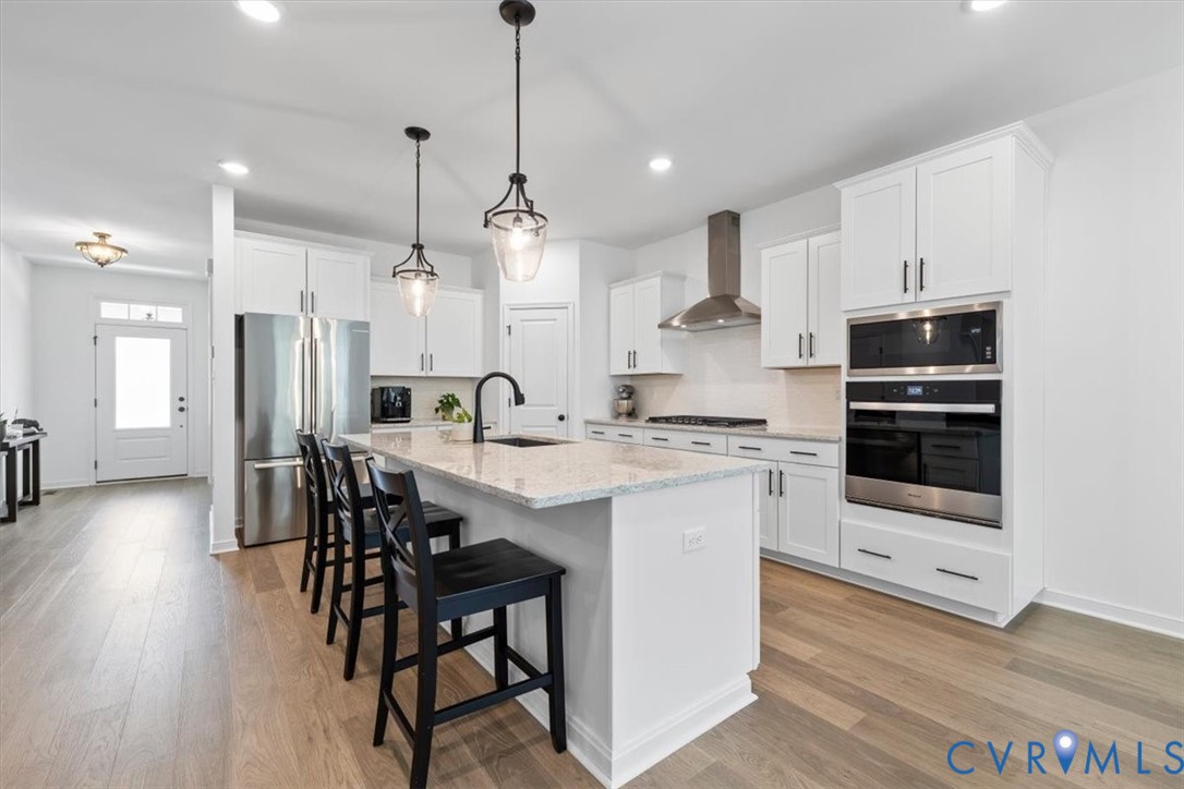 17131 Westington Road Moseley, VA 23120 - Photo 13 of 34 a kitchen with stainless steel appliances kitchen island a table chairs refrigerator and microwave