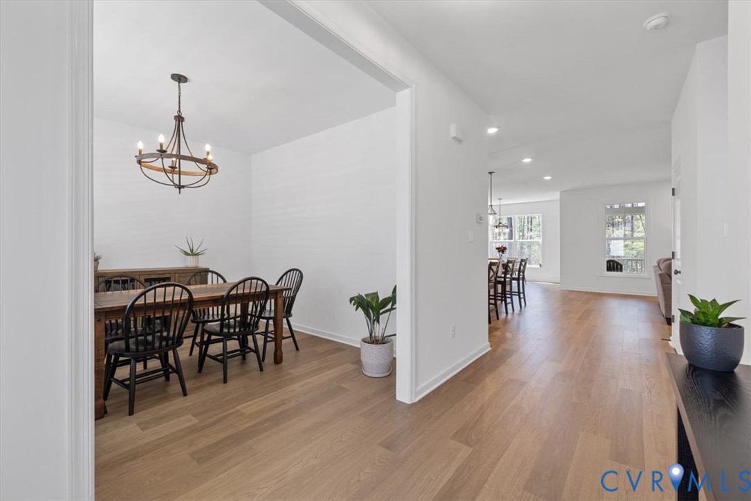17131 Westington Road Moseley, VA 23120 - Photo 9 of 34 a dining room with furniture wooden floor a potted plant and a chandelier