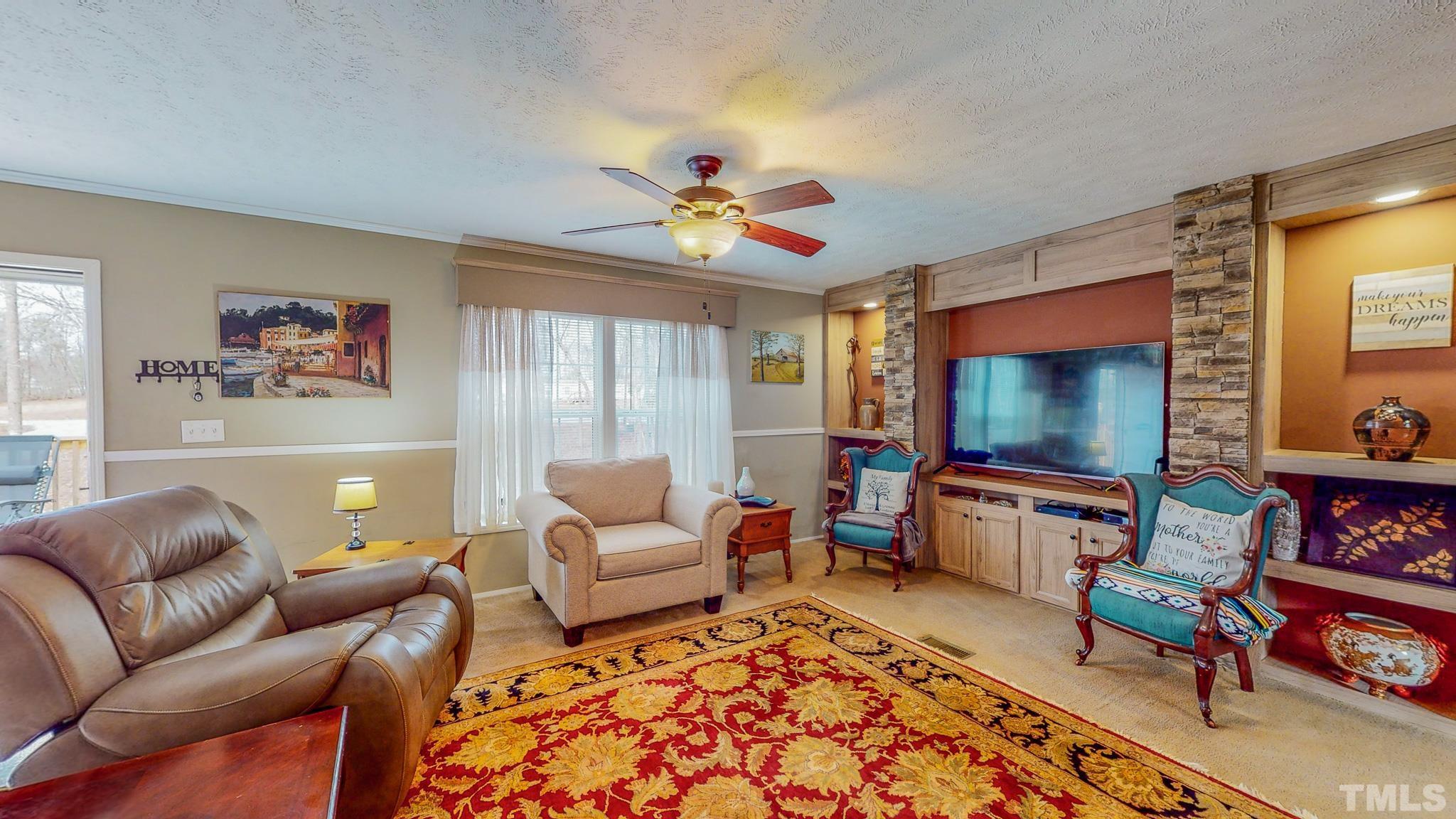 100 Marco Road Roxboro, NC 27574 - Photo 8 of 47 a living room with furniture a rug and a flat screen tv